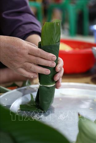 Trong ảnh: Gói bánh ống đòi hỏi sự khéo léo, cẩn thận để đảm bảo bánh bảo quản được lâu, dền và đẹp mắt. Nếu không khéo, bánh rất dễ một đầu to, một đầu nhỏ và lỏng lẻo. Ảnh: Trọng Đạt-TTXVN