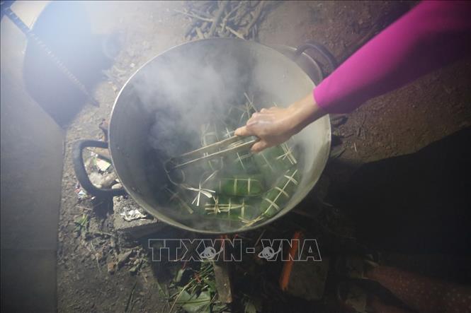 Trong ảnh: Sau khi gói xong, xếp bánh vào nồi, lót lá dong xuống đáy và trên cùng để không bị cháy và giữ được hơi. Bánh được luộc trong khoảng 12 – 15 giờ, sau khi luộc xong, rửa bánh trong nước lạnh cho sạch nhựa, để ráo hoặc túm lại treo lên. Ảnh: Trọng Đạt-TTXVN