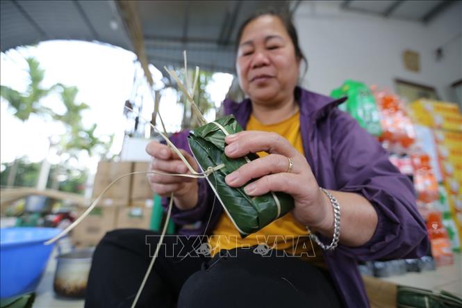Trong ảnh: Gói bánh ống đòi hỏi sự khéo léo, cẩn thận để đảm bảo bánh bảo quản được lâu, dền và đẹp mắt. Nếu không khéo bánh rất dễ một đầu to, một đầu nhỏ và lỏng lẻo. Ảnh: Trọng Đạt-TTXVN