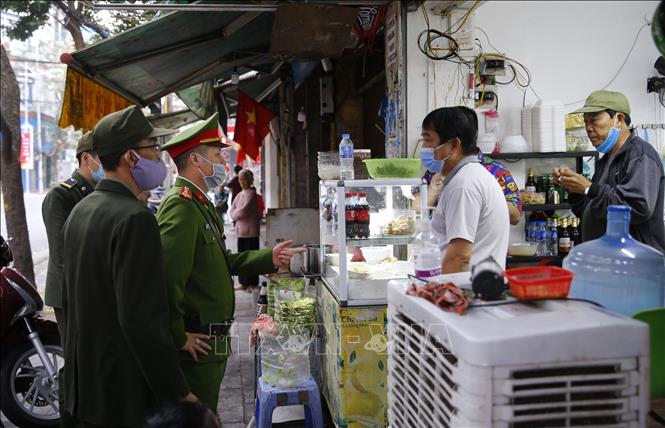 Trong ảnh: Lực lượng chức năng phường Hàng Mã, quận Hoàn Kiếm đề nghị các hộ kinh doanh thực hiện nghiêm quyết định của Ban chỉ đạo phòng, chống dịch COVID-19 TP Hà Nội. Ảnh: Doãn Tấn - TTXVN