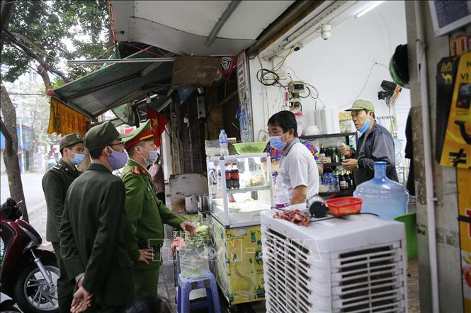 Trong ảnh: Lực lượng chức năng phường Hàng Mã, quận Hoàn Kiếm đề nghị các hộ kinh doanh thực hiện nghiêm quyết định của Ban chỉ đạo phòng, chống dịch COVID-19 TP Hà Nội. Ảnh: Doãn Tấn - TTXVN