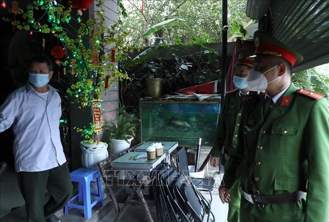 Trong ảnh: Lực lượng Công an nhắc nhở người dân việc thực hiện đóng cửa quán cà phê tại khu đô thị Văn Quán, quận Hà Đông. Ảnh: Phan Tuấn Anh - TTXVN