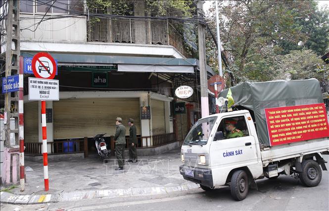 Trong ảnh: Lực lượng chức năng phường Hàng Mã, quận Hoàn Kiếm đề nghị các hộ kinh doanh thực hiện nghiêm quyết định của Ban chỉ đạo phòng, chống dịch COVID-19 TP Hà Nội. Ảnh: Doãn Tấn - TTXVN