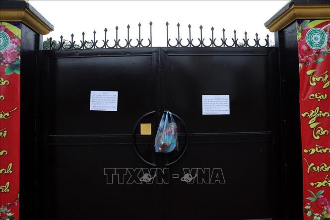 Trong ảnh: Không được vào trong đình, đền, chùa, nhiều người đã để lễ cúng ngay ở cửa. Ảnh: Phan Tuấn Anh - TTXVN 