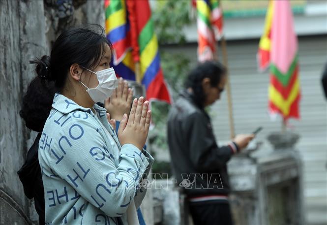 Trong ảnh: Không vào được đền chùa, người dân phải hành lễ bên ngoài. Ảnh: Phan Tuấn Anh - TTXVN 