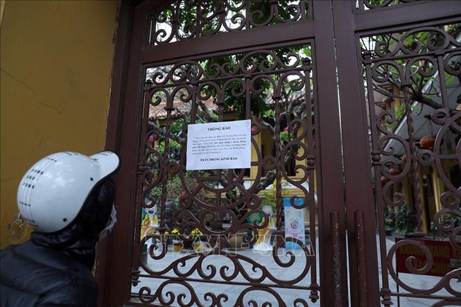 Trong ảnh: Người dân đọc thông báo đóng cửa tại Chùa Quán Sứ, trụ sở của Giáo hội Phật giáo Việt Nam. Ảnh: Phan Tuấn Anh - TTXVN 