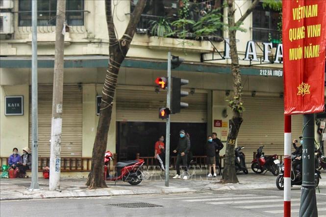 Một số quán cà phê trên phố Bà Triệu (Hà Nội) vẫn mở nhưng chuyển sang hình thức bán mang về hoặc bán qua mạng. Tại đây chỉ còn lại các bạn nhân viên và không nhận khách ngồi tại quán. Ảnh: Minh Nghĩa - TTXVN.