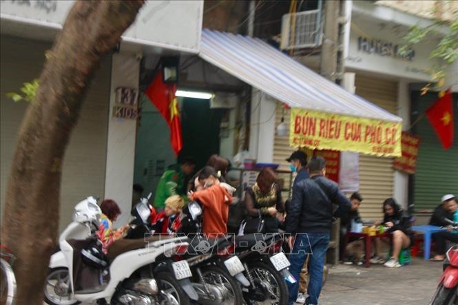 Hàng quán bán đồ ăn chủ yếu đông shipper đến lấy hàng cho khách. Ít người dân tới quán ăn vì lo ngại dịch bệnh. Ảnh: Minh Nghĩa - TTXVN. 

