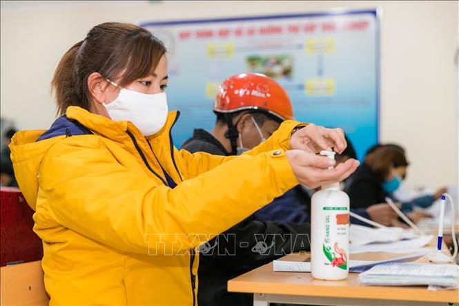 Trong ảnh: Nhiều lao động đến Trung tâm dịch vụ việc làm đều phải thực hiện đeo khẩu trang và sát khuẩn theo quy định. Ảnh: Bích Huệ - TTXVN