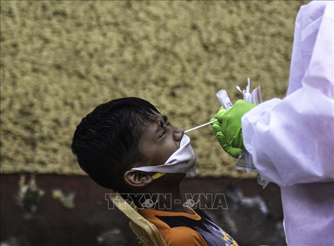 Trong ảnh: Nhân viên y tế lấy mẫu xét nghiệm COVID-19 cho trẻ em tại Mumbai, Ấn Độ, ngày 19/2/2021. Ảnh: THX/ TTXVN