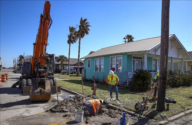 Trong ảnh: Công nhân sửa chữa đường ống nước bị vỡ do bão tuyết tại Galveston, bang Texas, Mỹ ngày 19/2/2021. Ảnh: AFP/TTXVN