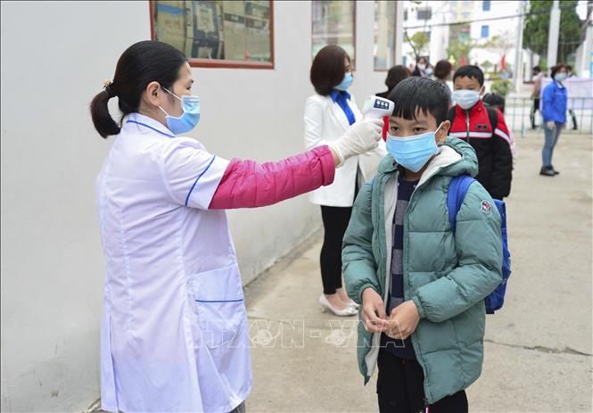 Trong ảnh: Kiểm tra thân nhiệt cho học sinh trước khi vào lớp tại trường Tiểu học Him Lam (thành phố Điện Biên Phủ). Ảnh: Xuân Tư - TTXVN