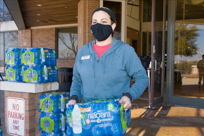 Trong ảnh: Tình nguyện viên phát nước sạch cho người dân tại ngoại ô thành phố Dallas, bang Texas, Mỹ ngày 20/2/2021. Ảnh: THX/TTXVN