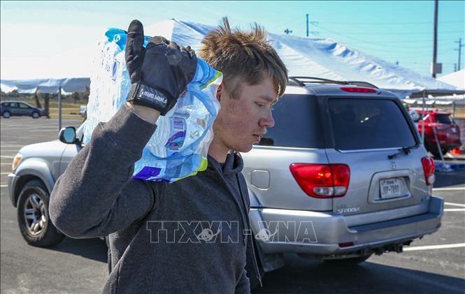 Trong ảnh: Tình nguyện viên chuyển nước sạch cho người dân tại khu cư dân Galveston ở bang Texas, Mỹ ngày 19/2/2021. Ảnh: AFP/TTXVN
