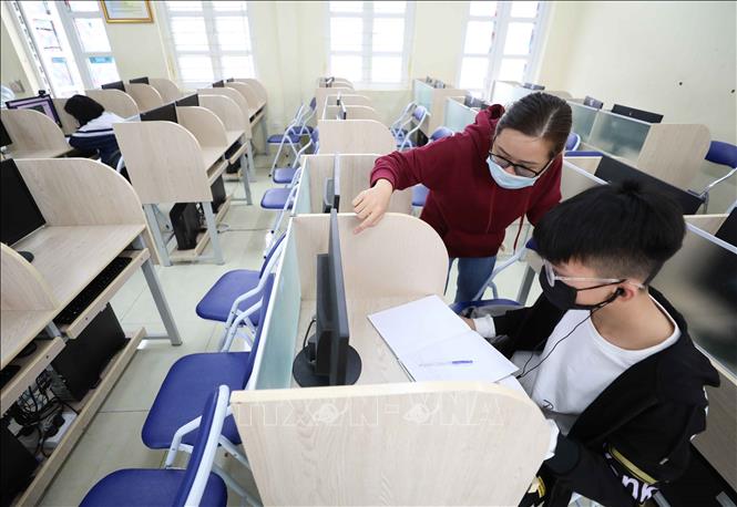 Trong ảnh: Học sinh trường THCS Thăng Long (Ba Đình, Hà Nội) không có điều kiện học trực tuyến tại nhà được nhà trường bố trí và phân công giáo viên giúp đỡ học tại phòng máy của trường. Ảnh: Thanh Tùng - TTXVN