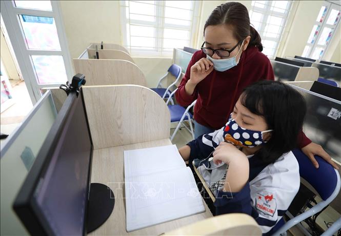 Trong ảnh: Học sinh trường THCS Thăng Long (Ba Đình, Hà Nội) không có điều kiện học trực tuyến tại nhà được nhà trường bố trí và phân công giáo viên giúp đỡ học tại phòng máy của trường. Ảnh: Thanh Tùng - TTXVN