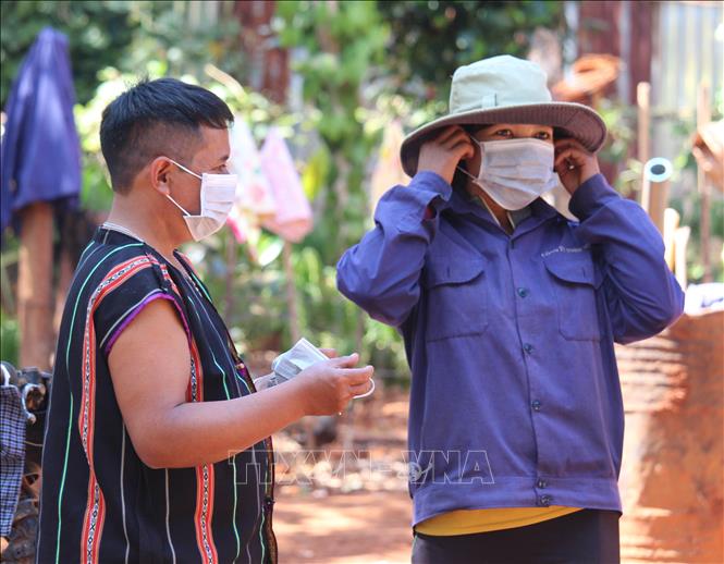 Trong ảnh: Ông Rơ Mah Chel (trái) đến từng hộ gia đình tuyên truyền đến người dân cách phòng, chống dịch COVID-19 bằng cách đeo khẩu trang ở nơi công cộng. Ảnh: Hồng Điệp - TTXVN
