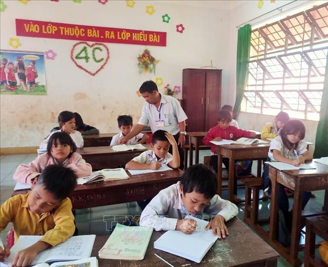 Trong ảnh: Ông Rơ Mah Chel dạy chữ cho học sinh dân tộc thiểu số vùng sâu, vùng xa của tỉnh Gia Lai. Ảnh: Hồng Điêp - TTXVN 