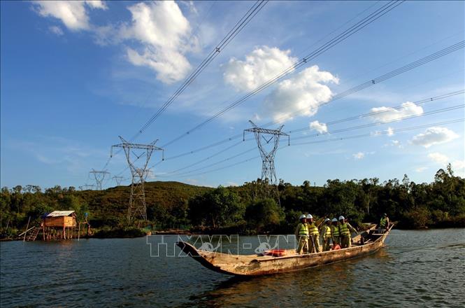 Photo: Workers check the transmission line in the central province of Quang Binh. VNA Photo: Ngọc Hà