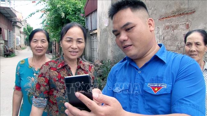 Trong ảnh: Trưởng thôn Sàng xã Đạo Lý, huyện Lý Nhân Nguyễn Văn Huynh (sinh năm 1990) hướng dẫn bà con trong việc sử dụng công nghệ thông tin vào việc bảo đảm an toàn anh ninh thôn xóm.  Ảnh: Đại Nghĩa - TTXVN