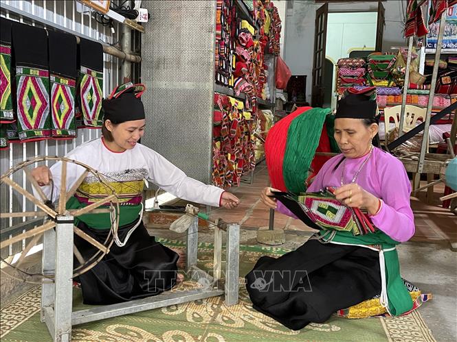 Trong ảnh: Bằng tâm huyết và đam mê, bà Phạm Thị Bảo (phải) đã truyền lửa cho những người phụ nữ Mường cùng bảo tồn và phát huy nghề dệt thổ cẩm truyền thống của dân tộc mình. Ảnh: Khiếu Tư -TTXVN