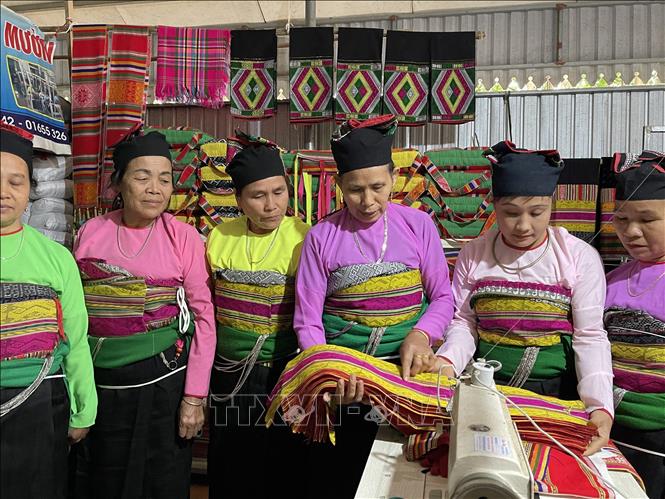 Trong ảnh: Sau khi sản phẩm hoàn thành, bà Bảo tận tình chỉ bảo cho các chị em để làm sao sản phẩm làm ra đạt chất lượng tốt nhất, đường kim mũi chỉ đẹp nhất. Ảnh: Khiếu Tư -TTXVN
