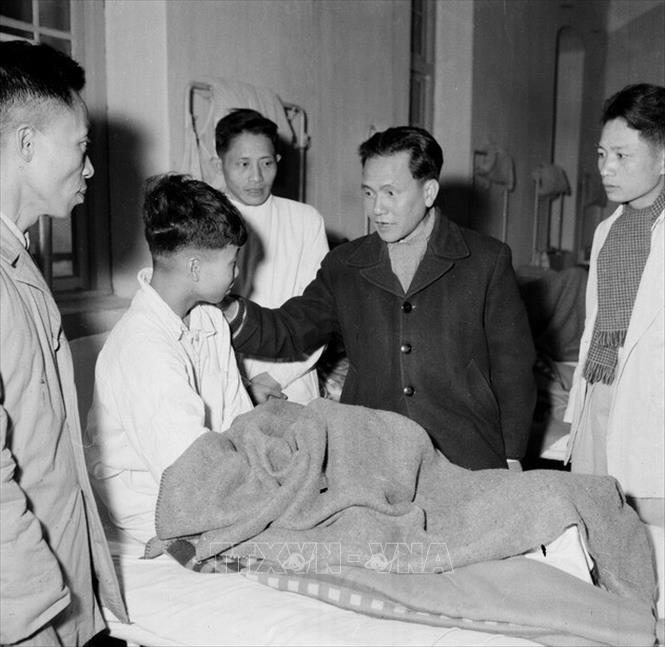 Trong ảnh: Bộ trưởng Bộ Công nghiệp Lê Thanh Nghị thăm hỏi, động viên công nhân đang nằm viện (25/01/1960). Ảnh: TTXVN
