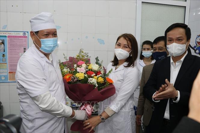 Trong ảnh: Thứ trưởng Bộ Y Tế Đỗ Xuân Tuyên tặng hoa chúc mừng nhân viên y tế Hải Dương sau khi được tiêm vaccine phòng dịch COVID-19. Ảnh: Mạnh Minh - TTXVN