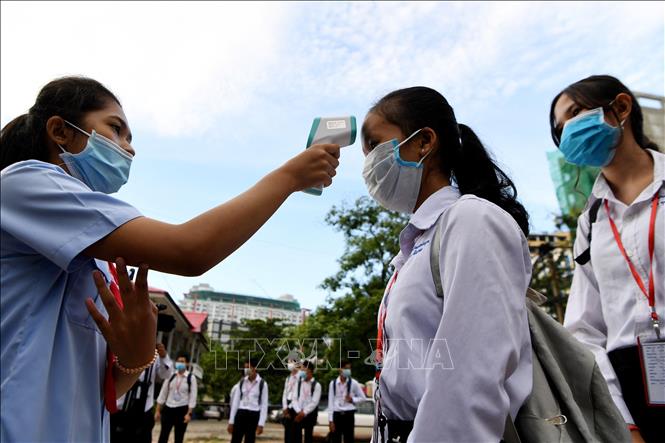 Trong ảnh: Học sinh được kiểm tra thân nhiệt trước khi vào lớp nhằm ngăn dịch COVID-19 lây lan tại Phnom Penh, Campuchia ngày 7/9/2020. Ảnh: AFP/TTXVN