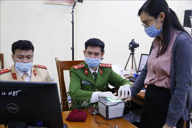 Trong ảnh: Lực lượng Công an quận Hai Bà Trưng làm thủ tục lấy dấu vân tay, tăng ca đêm làm căn cước công dân cho người dân tại Trụ sở Công an quận (số 94 Tô Hiến Thành) (ảnh chụp lúc 21h30 tối 10/3/2021). Ảnh: Doãn Tấn - TTXVN