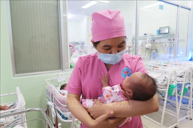 Trong ảnh: Nữ hộ sinh Khoa Sơ sinh chăm sóc một đứa trẻ sinh non bị bỏ rơi. Ảnh: Đinh Hằng - TTXVN