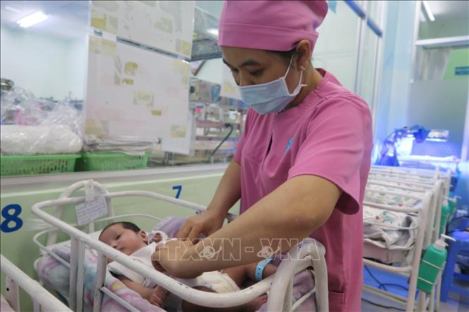 Trong ảnh: Nữ hộ sinh Khoa Sơ sinh chăm sóc trẻ sinh non bị bỏ rơi. Ảnh: Đinh Hằng - TTXVN