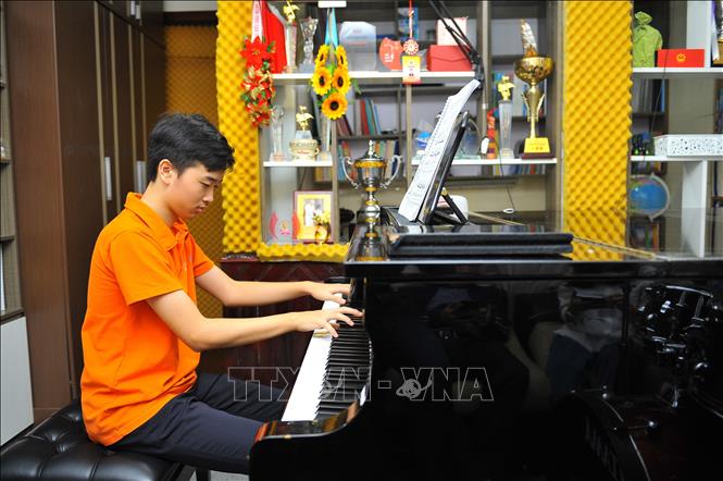Võ Minh Quang luyện tập piano tại nhà. Ảnh: Minh Đức - TTXVN