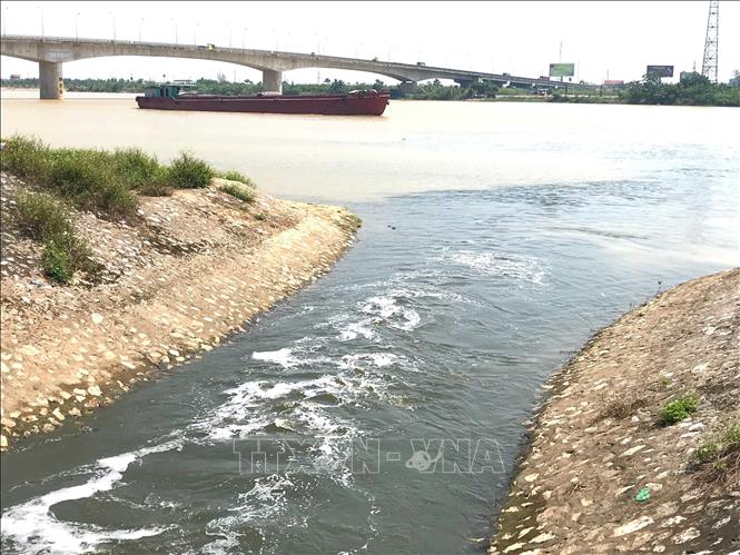 Nước xả chưa qua xử lý của Trạm bơm Quán Chuột chảy ra sông Hồng, đoạn gần cầu Tân Phong (xã Mỹ Tân, huyện Mỹ Lộc, tỉnh Nam Định) gây ô nhiễm môi trường. Ảnh: Công Luật - TTXVN