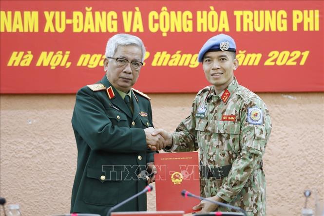 Photo: Deputy Defence Minister Sen. Lieut. Gen Nguyen Chi Vinh hands over the President’s decision to send Lieut. Col Tran Duc Huong. VNA Photo: Dương Giang 