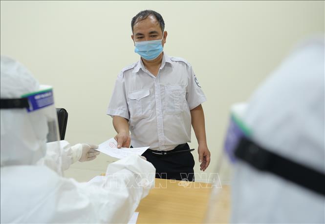 Trong ảnh: Công nhân viên Bến xe Giáp Bát khai báo y tế trước khi xét nghiệm. Ảnh: Hoàng Hiếu - TTXVN