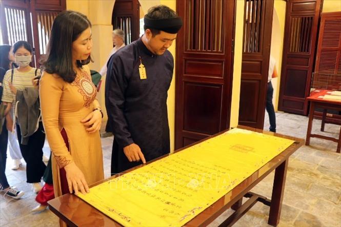Du khách tham quan hiện vật trưng bày tại không gian Tàng Thơ Lâu. Ảnh: Đỗ Trưởng - TTXVN