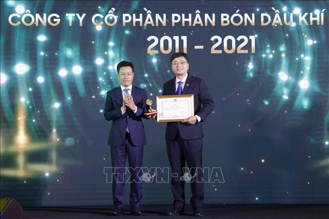 Photo: Chairman of the People’s Committee of Ca Mau Le Quan (L) presents the certificate of merit to PVCFC. VNA Photo: Kim Há