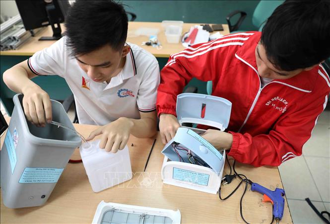 Trong ảnh: Sinh viên năm thứ hai, khoa Chế tạo Máy (trường Đại học Bách khoa Hà Nội) lắp ráp máy rửa tay diệt khuẩn tự động với hai mẫu mã, kích thước khác nhau, rất tiện ích trong việc rửa tay khử khuẩn tại những nơi công cộng, không mất nhiều thời gian và tránh việc tiếp xúc với bề mặt máy có thể gây lây nhiễm, đóng góp cho cộng đồng để phòng chống COVID-19. Ảnh: Thanh Tùng - TTXVN