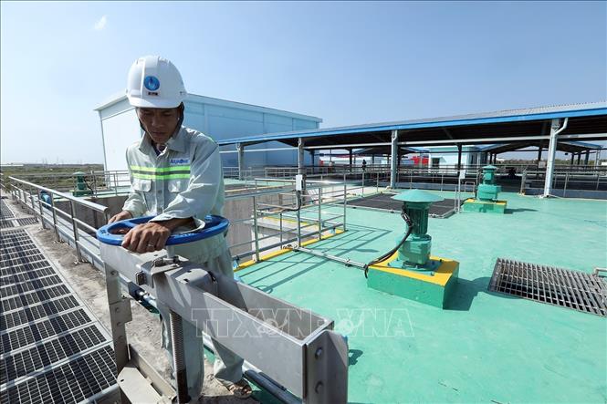 Trong ảnh: Công nhân vận hành van cửa đóng, mở lấy nước. Ảnh: Phan Tuấn Anh - TTXVN