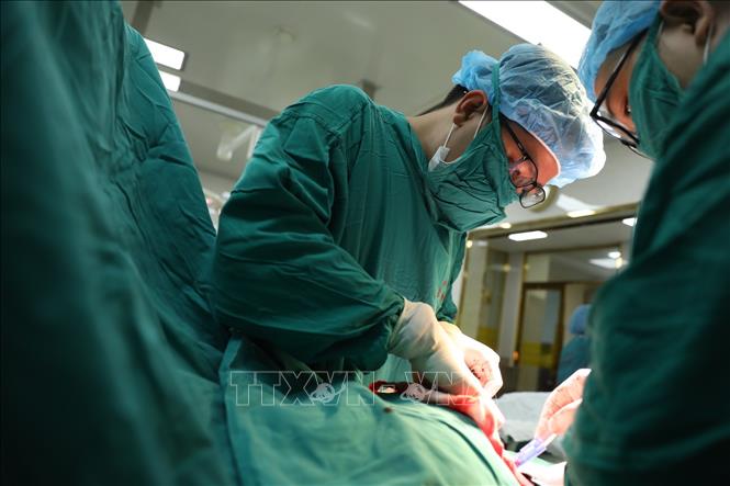 Trong ảnh: Bác sĩ Trần Anh Đức phẫu thuật cho sản phụ 37 tuổi, phải mổ vì thai 33 tuần 4 ngày nhưng thai chậm phát triển, thai suy, hết ối. Ảnh: Minh Quyết - TTXVN
