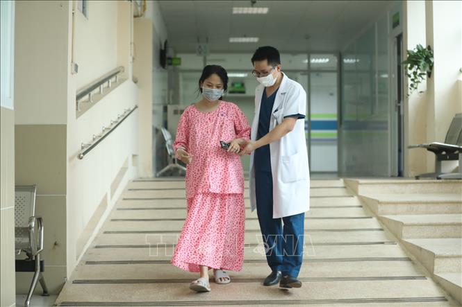 Trong ảnh: ThS.BS Trần Anh Đức luôn quan tâm đến bệnh nhân của mình. Ảnh: Minh Quyết - TTXVN