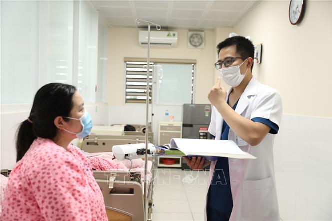 Trong ảnh: ThS.BS Trần Anh Đức luôn quan tâm đến bệnh nhân của mình. Ảnh: Minh Quyết - TTXVN