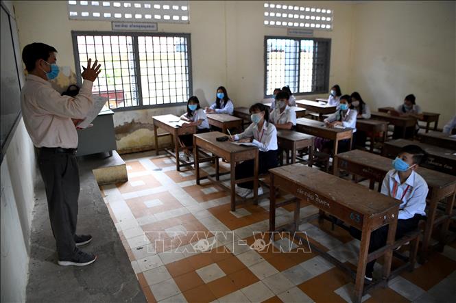 Trong ảnh: Học sinh đeo khẩu trang phòng lây nhiễm COVID-19 trong lớp học tại Phnom Penh, Campuchia. Ảnh: AFP/ TTXVN