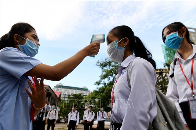 Trong ảnh: Kiểm tra thân nhiệt phòng lây nhiễm COVID-19 trong lớp học tại Phnom Penh, Campuchia. Ảnh: AFP/ TTXVN