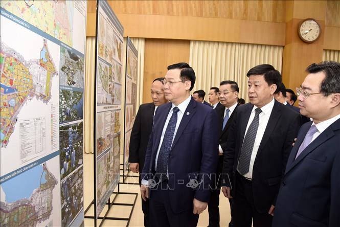 Trong ảnh: Ủy viên Bộ Chính trị, Bí thư Thành ủy Hà Nội Vương Đình Huệ cùng các đại biểu xem đồ án quy hoạch.  Ảnh: TTXVN