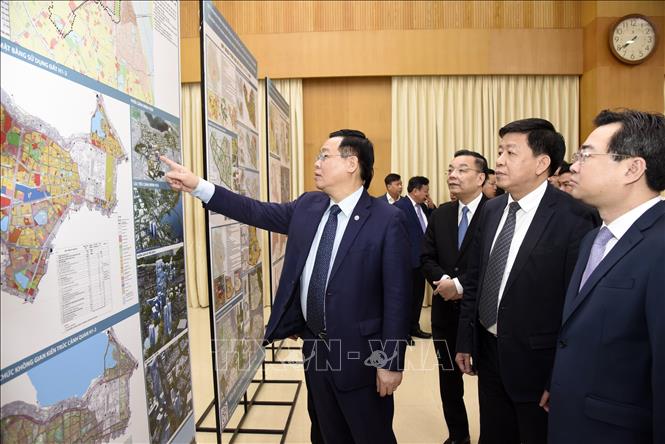 Trong ảnh: Ủy viên Bộ Chính trị, Bí thư Thành ủy Hà Nội Vương Đình Huệ cùng các đại biểu xem đồ án quy hoạch.  Ảnh: TTXVN