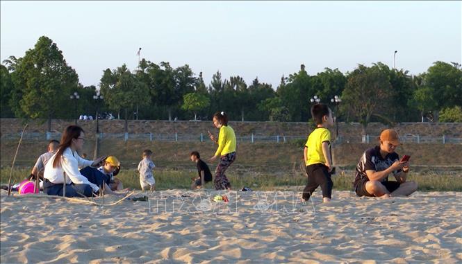 Trong ảnh: Nhiều gia đình đưa trẻ ra bãi cát trên sông Đăk Bla để vui chơi, giải trí. Ảnh: Khoa Chương – TTXVN