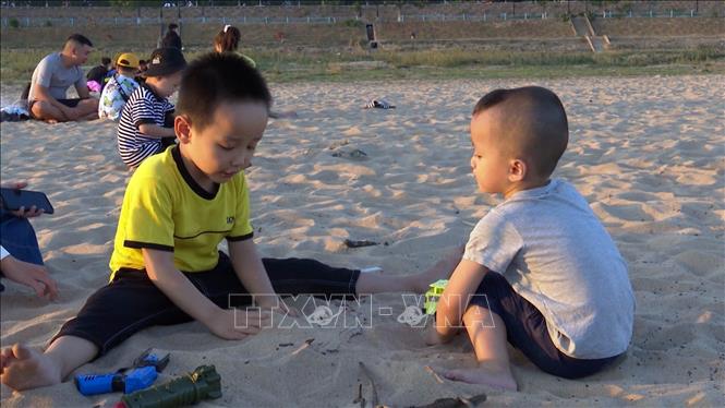 Trong ảnh: Trẻ em thích thú với những trò chơi trên cát. Ảnh: Khoa Chương – TTXVN