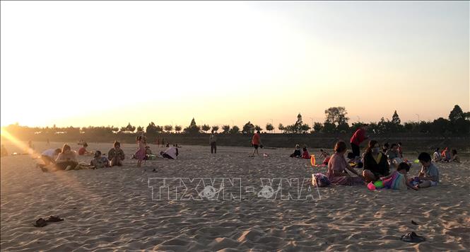 Trong ảnh: Bãi cát rộng thu hút nhiều gia đình đến vui chơi, giải trí. Ảnh: Khoa Chương – TTXVN